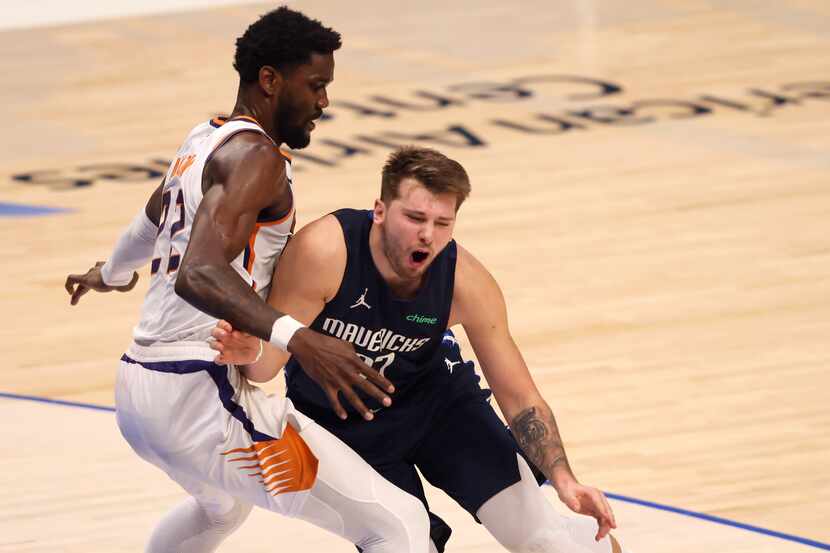 Dallas Mavericks guard Luka Doncic (77) is fouled by Phoenix Suns center Deandre Ayton (22)...