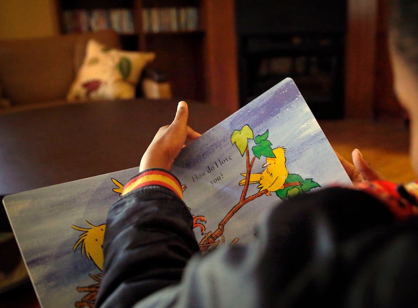 A 7-year-old resident reads a book in March 2016 at a Garland emergency children's shelter...