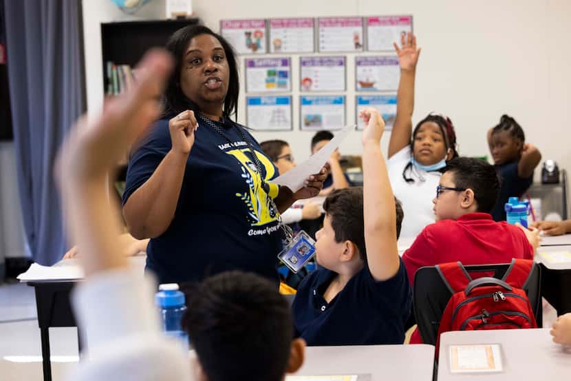 Students raise their hands as third grade teacher Anjelica Turner talks about character...