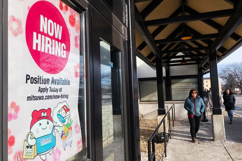 File - A hiring sign is displayed at a grocery store in Arlington Heights, Ill., Tuesday,...
