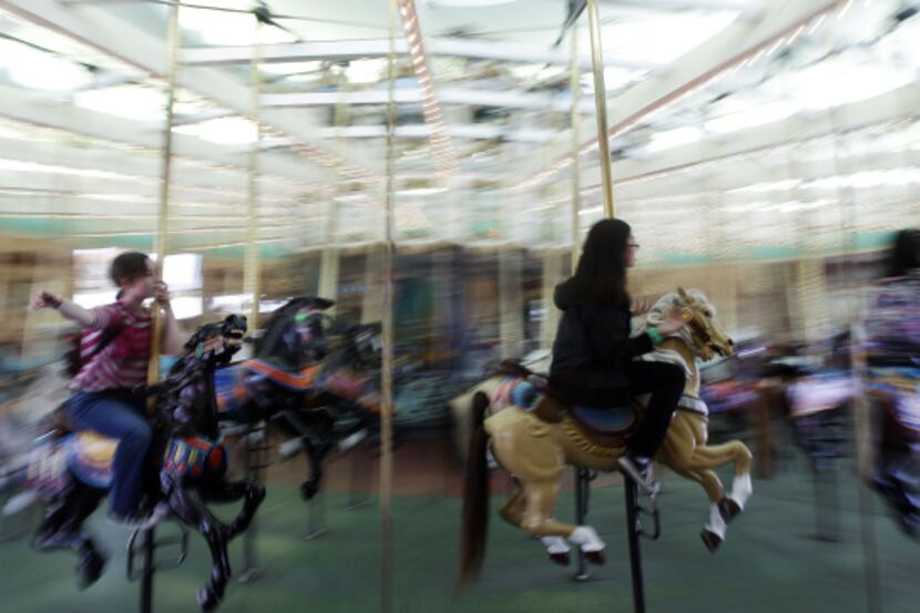 Families revel in old-fashioned summer fun at attractions such as the merry go-around at the...