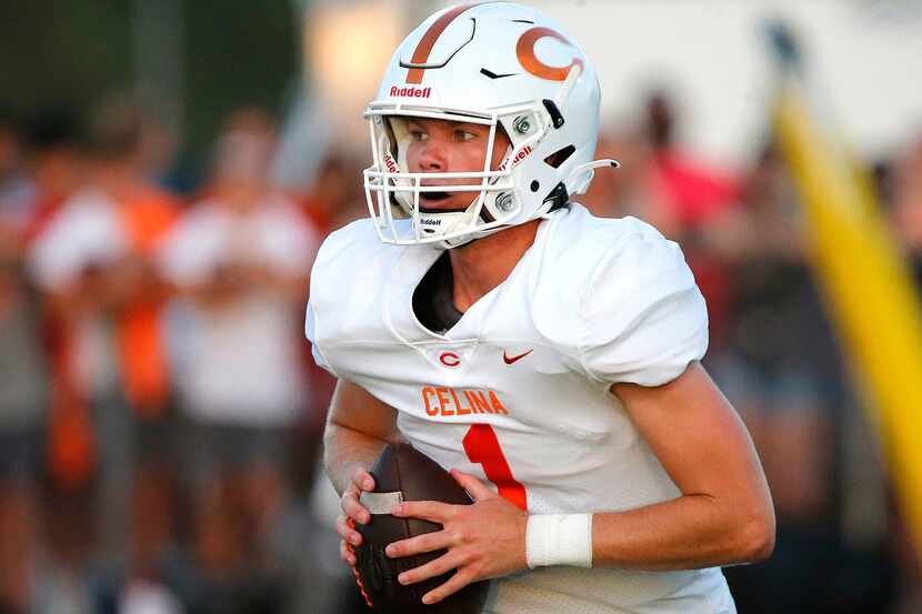 Celina High School quarterback Noah Bentley (1) rolls out to pass during the second half as...