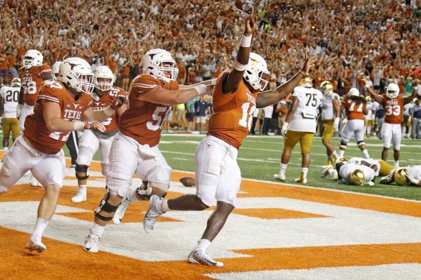 Texas quarterback Tyrone Swoopes (18) celebrates with teammates after scoring the winning...
