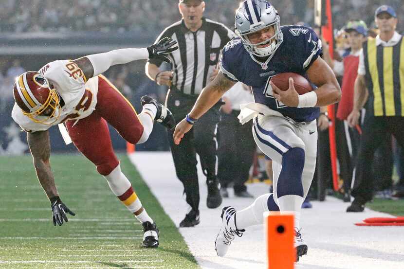 Dallas Cowboys quarterback Dak Prescott (4) heads out of bounds on a scramble during the...