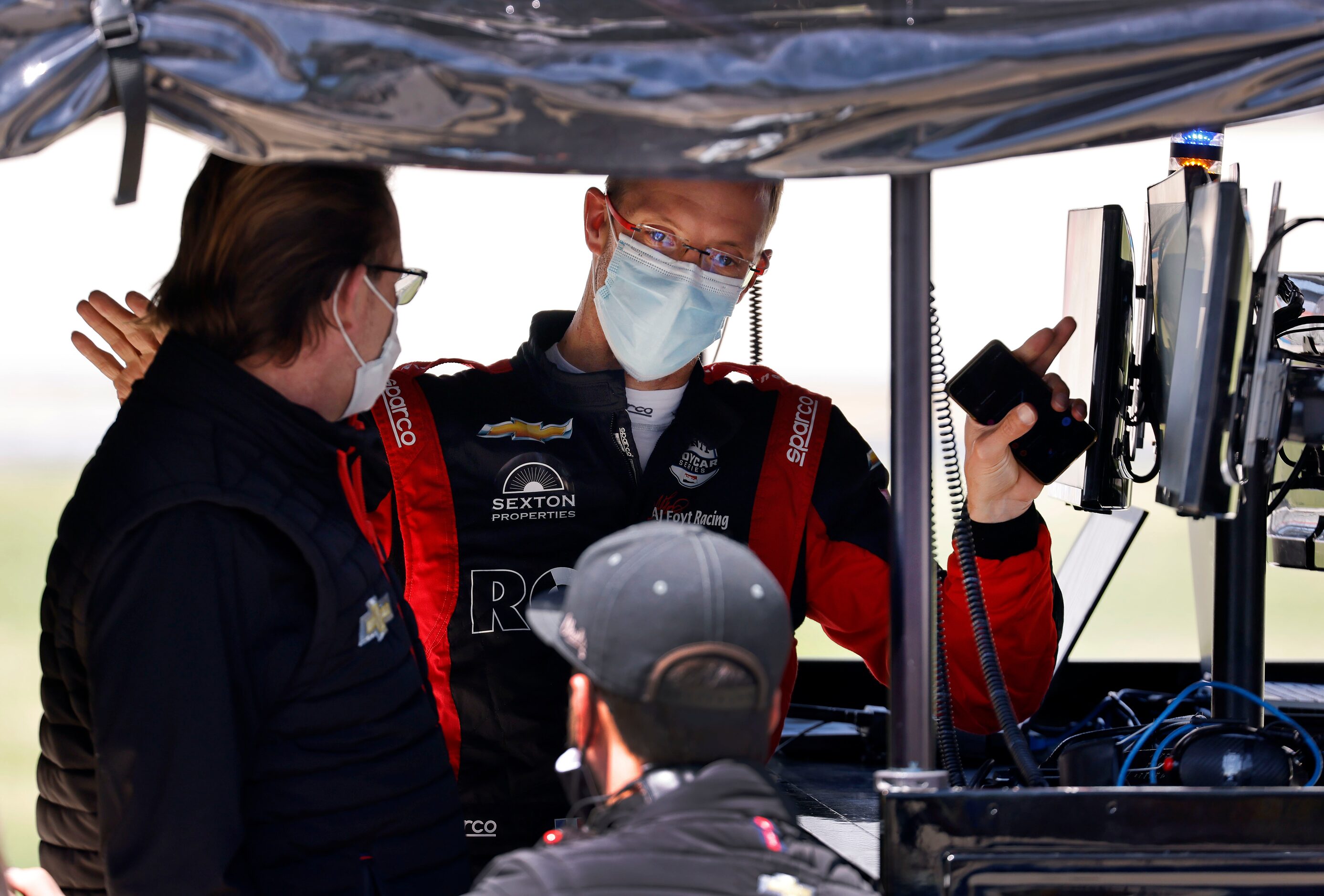 Indy Car driver Sébastien Bourdais visits with his crew after practicing for the upcoming...