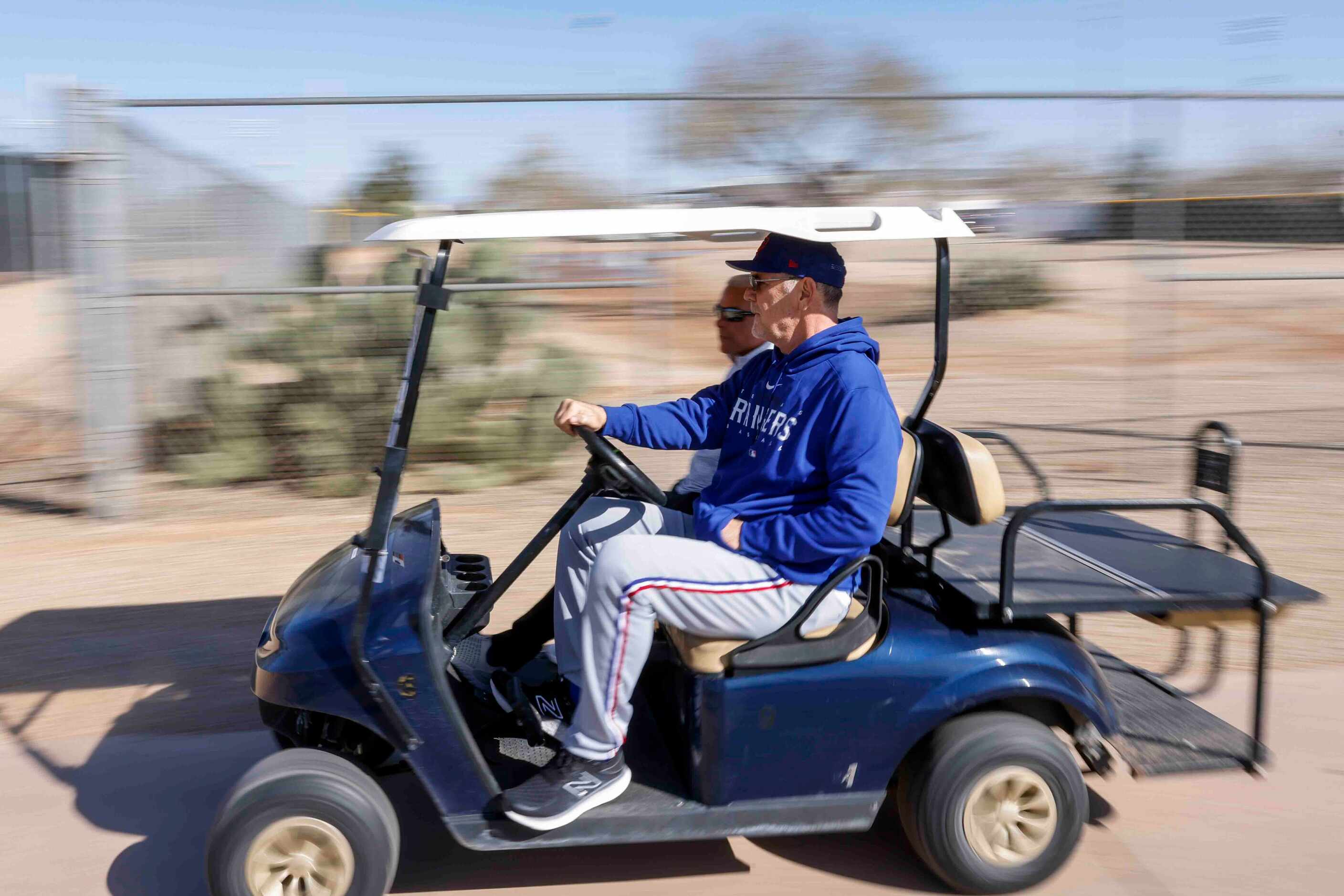 Texas Rangers manager Bruce Bochy drives a cart as he enters the team's training facility...