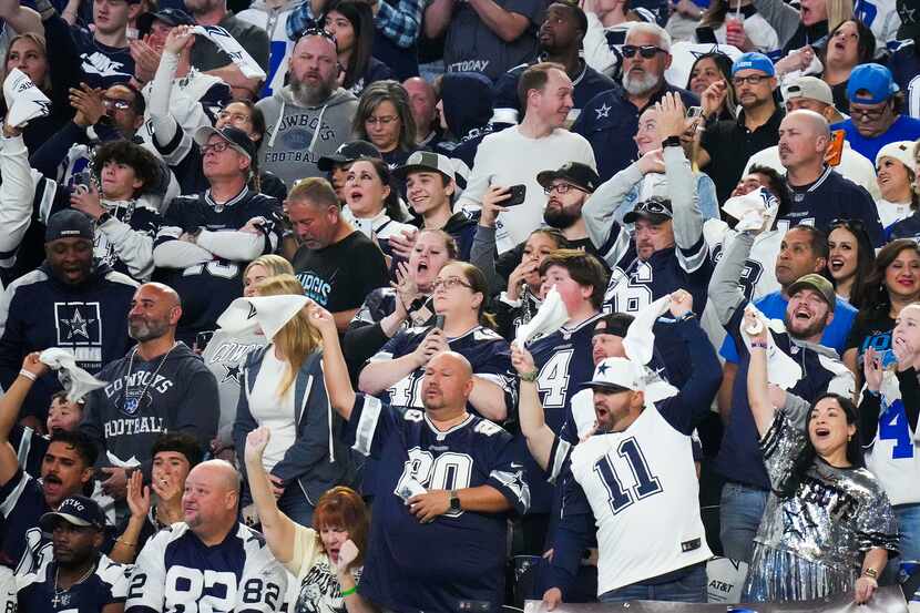 Dallas Cowboys fans cheer their team during the first half of an NFL football game against...