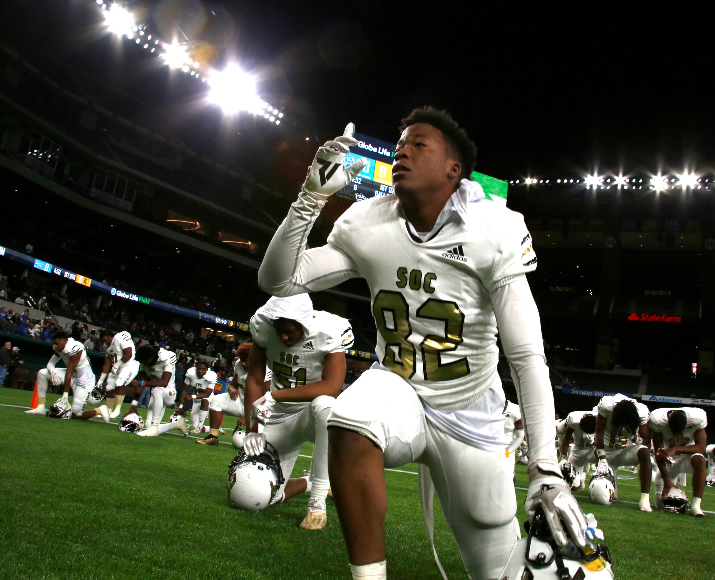 South Oak Cliff defensive lineman Robert Strahan (82) gestures upward as other teammates...