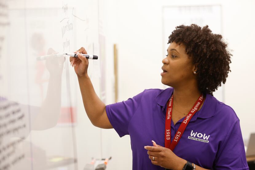 Working on Womanhood (WOW) youth specialist LaToya Davis writes on a white board while...