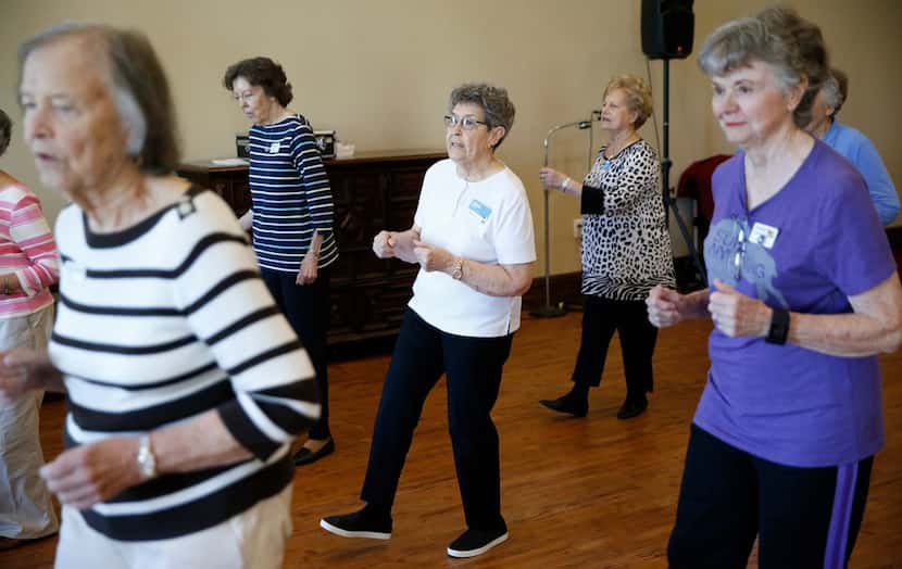 Louise Pierson (center) dances with her group during a line dancing class for seniors at...