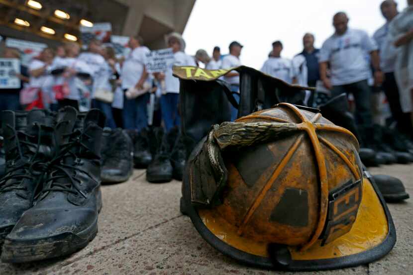 A helmet and boots of Dallas police and fire retirees lay on the ground at a rally at City...