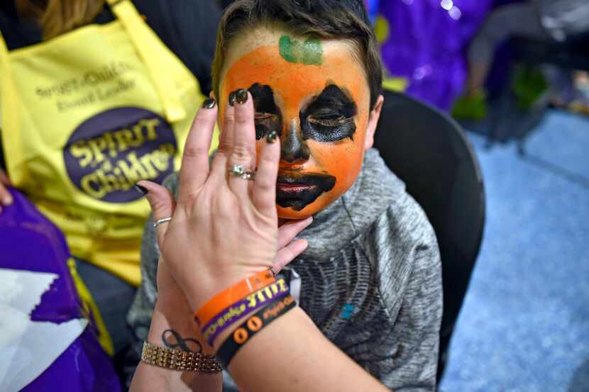 Hunter McCall, 10, of Tulsa, has a jack-o'-lantern painted on his face during a special...