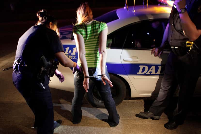 FILE - In this Nov. 4, 2009 file photo, Dallas police arrest a young woman for prostitution...