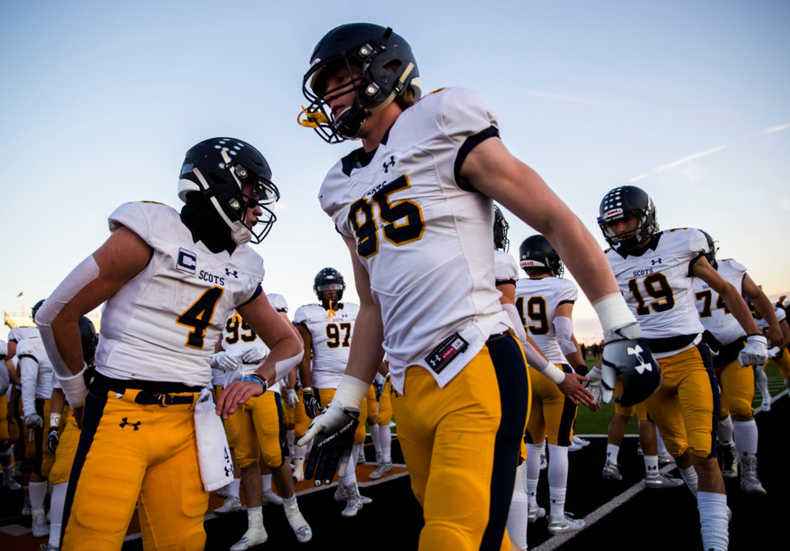 Highland Park quarterback Chandler Morris (4) high-fives defensive lineman Jack Curtis (95)...