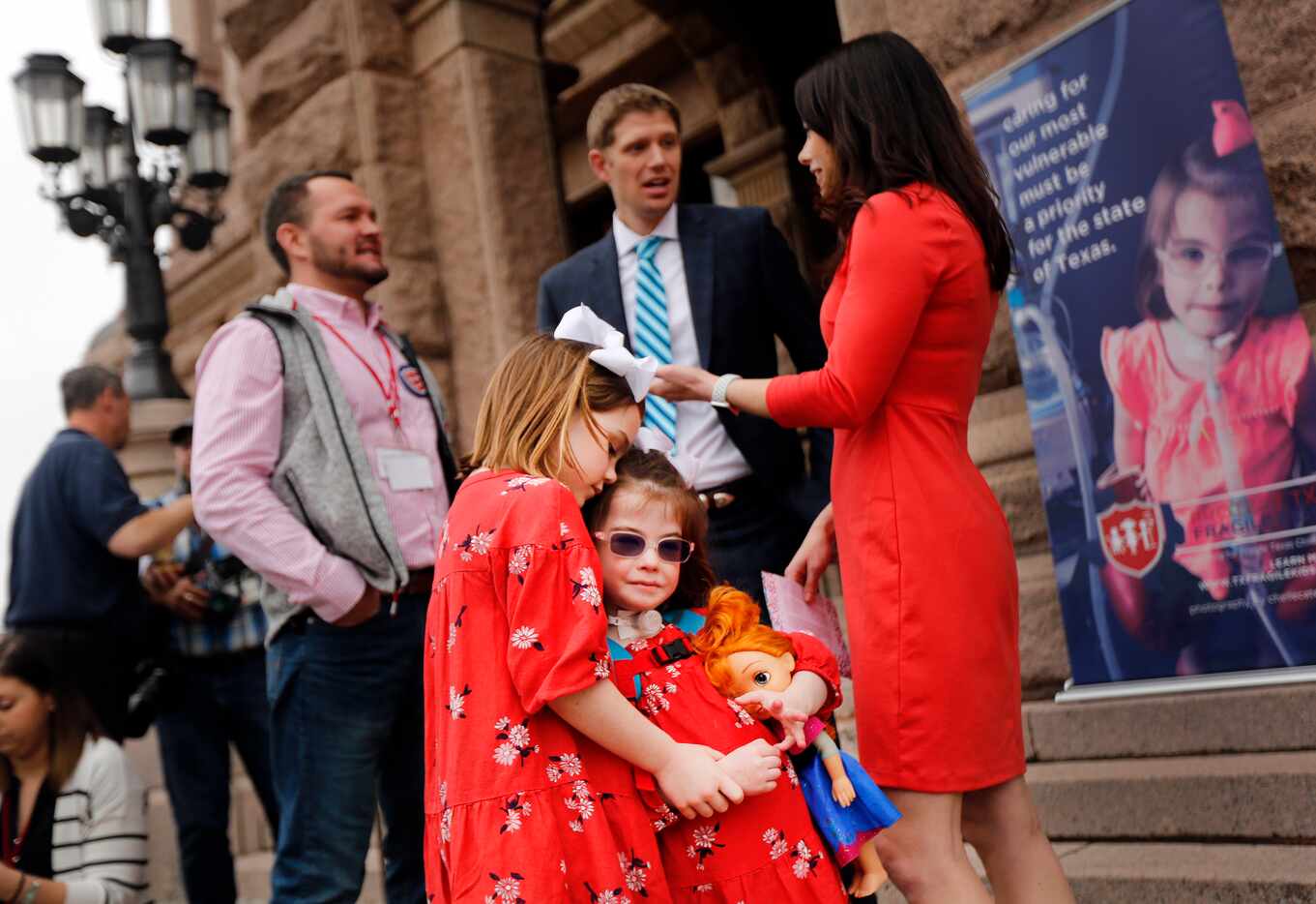 Grace Gregory (left) hugs her sister Tina Tuesday following a Protect Fragile TX Children...