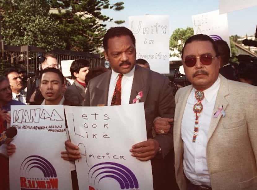 Rev. Jesse Jackson,  center, leads the picket line arm-in-arm with Ben Bulatao, left,  and...
