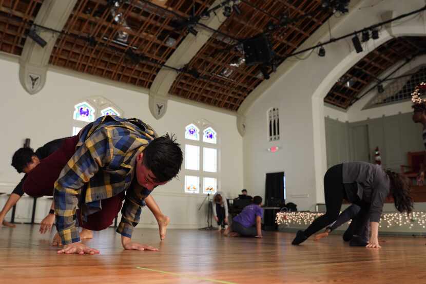 Dancers practice moves in large studio.