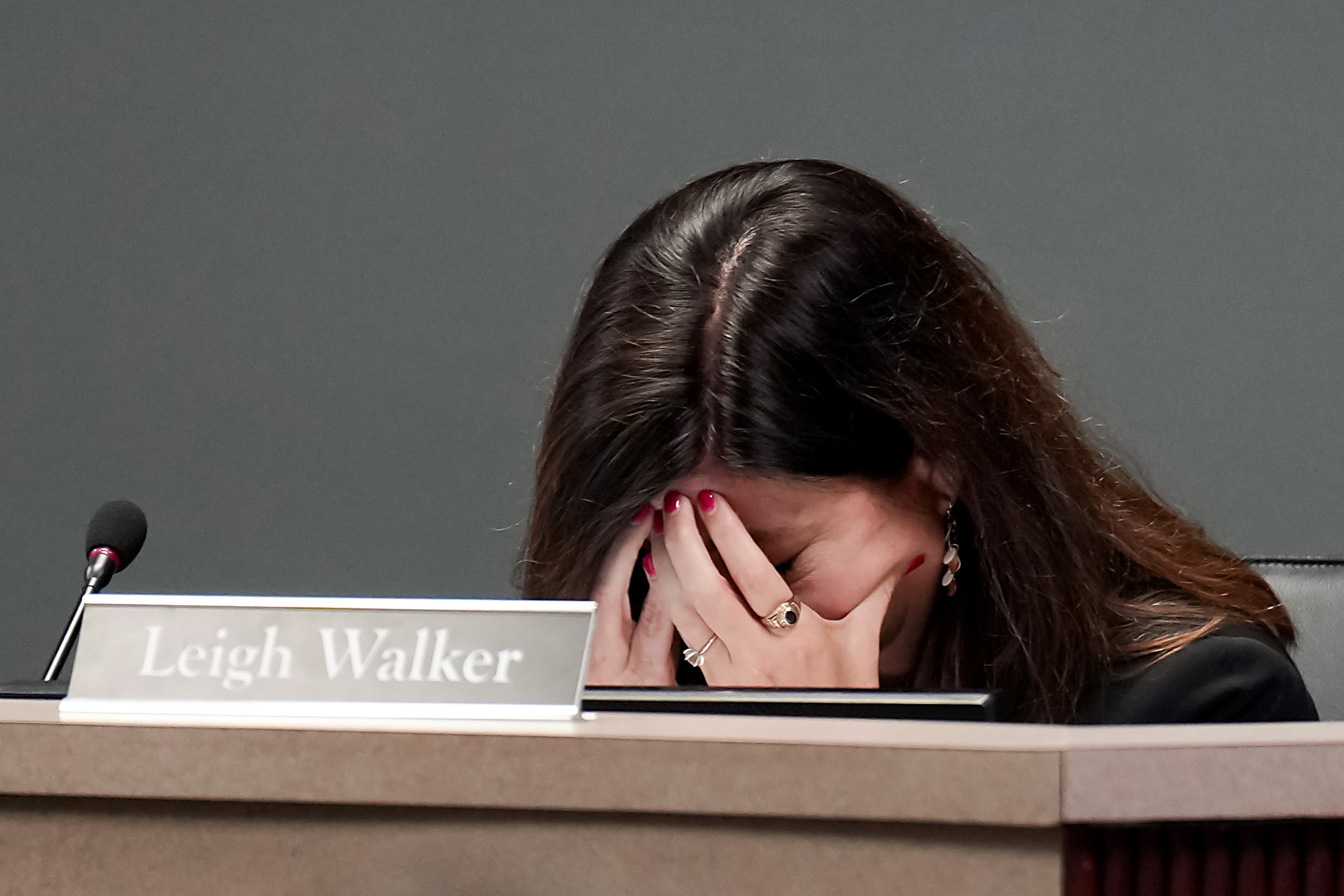 Coppell ISD school board member Leigh Walker buries her head in her hands during discussion...