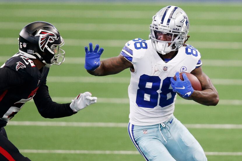 Dallas Cowboys wide receiver CeeDee Lamb (88) attempts to break away from Atlanta Falcons...