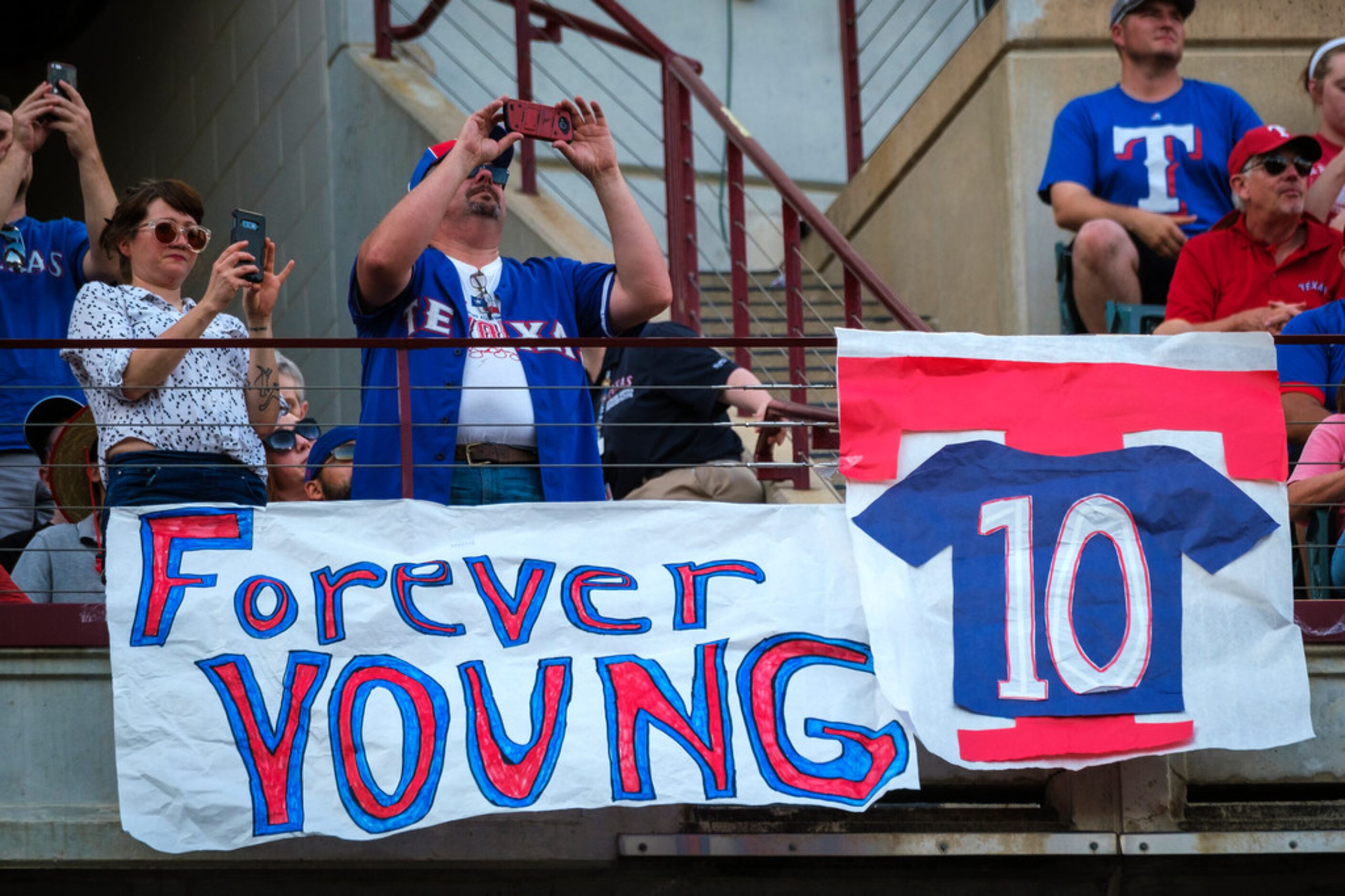 Fans cheer during ceremonies to retire Michael Young's No. 10 before a game against the...