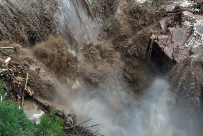 This aerial photo shows a raging waterfall destroying a bridge along Highway 34 toward Estes...