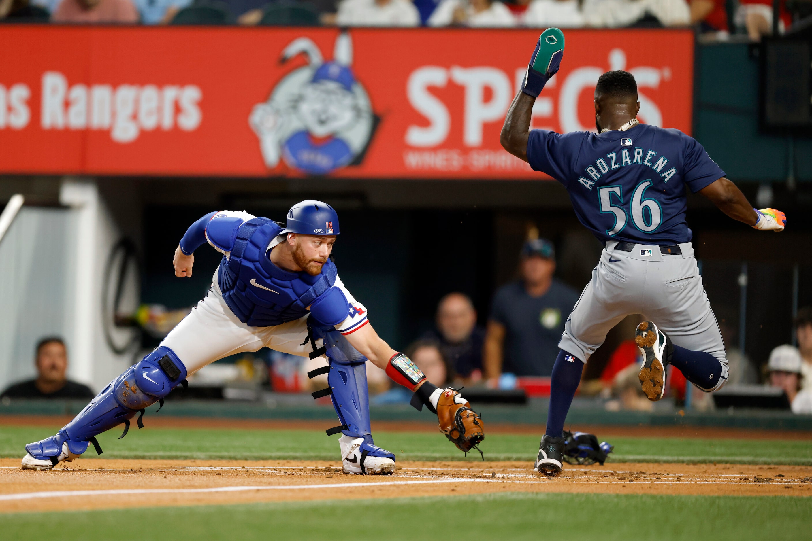 Seattle Mariners left fielder Randy Arozarena (56) scores a run ahead of the tag from Texas...