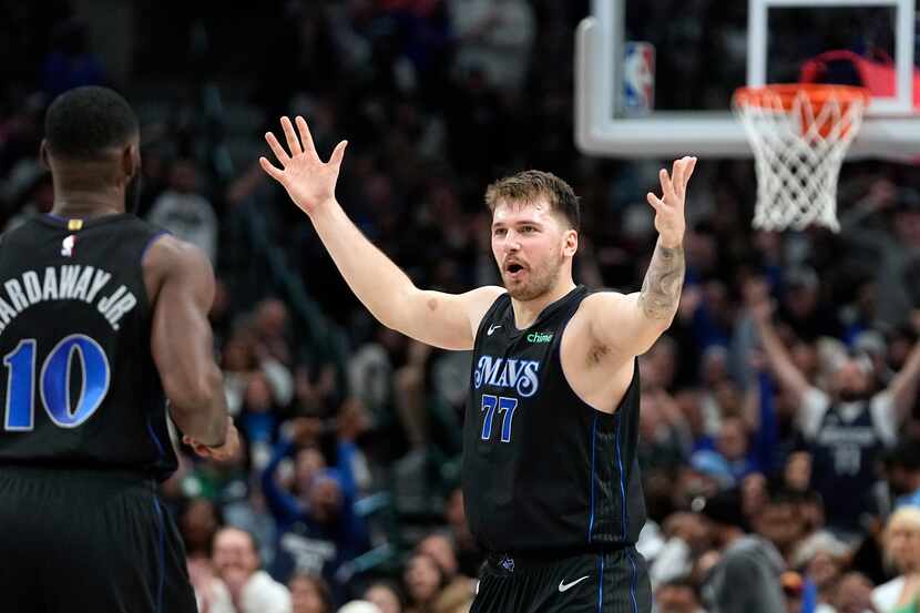 Dallas Mavericks guard Luka Doncic celebrates with teammates during the second half of an...