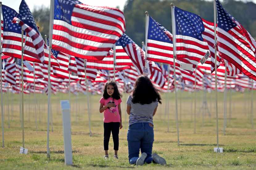 Ira Ravi, 5, and her mother, Bratibha, visit the Plano Flags of Honor at Oak Point Park. The...