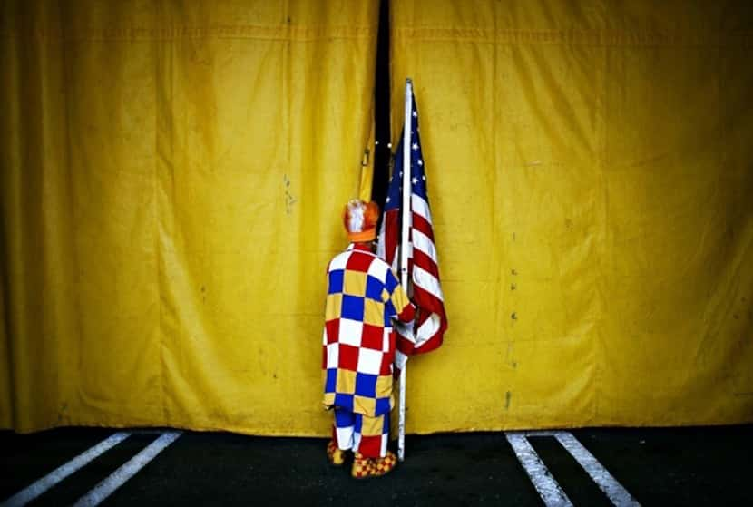  Perolito, a clown in the Cole Brothers Circus, sneaks a look into the tent just before his...