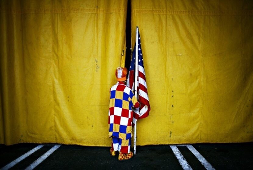  Perolito, a clown in the Cole Brothers Circus, sneaks a look into the tent just before his...