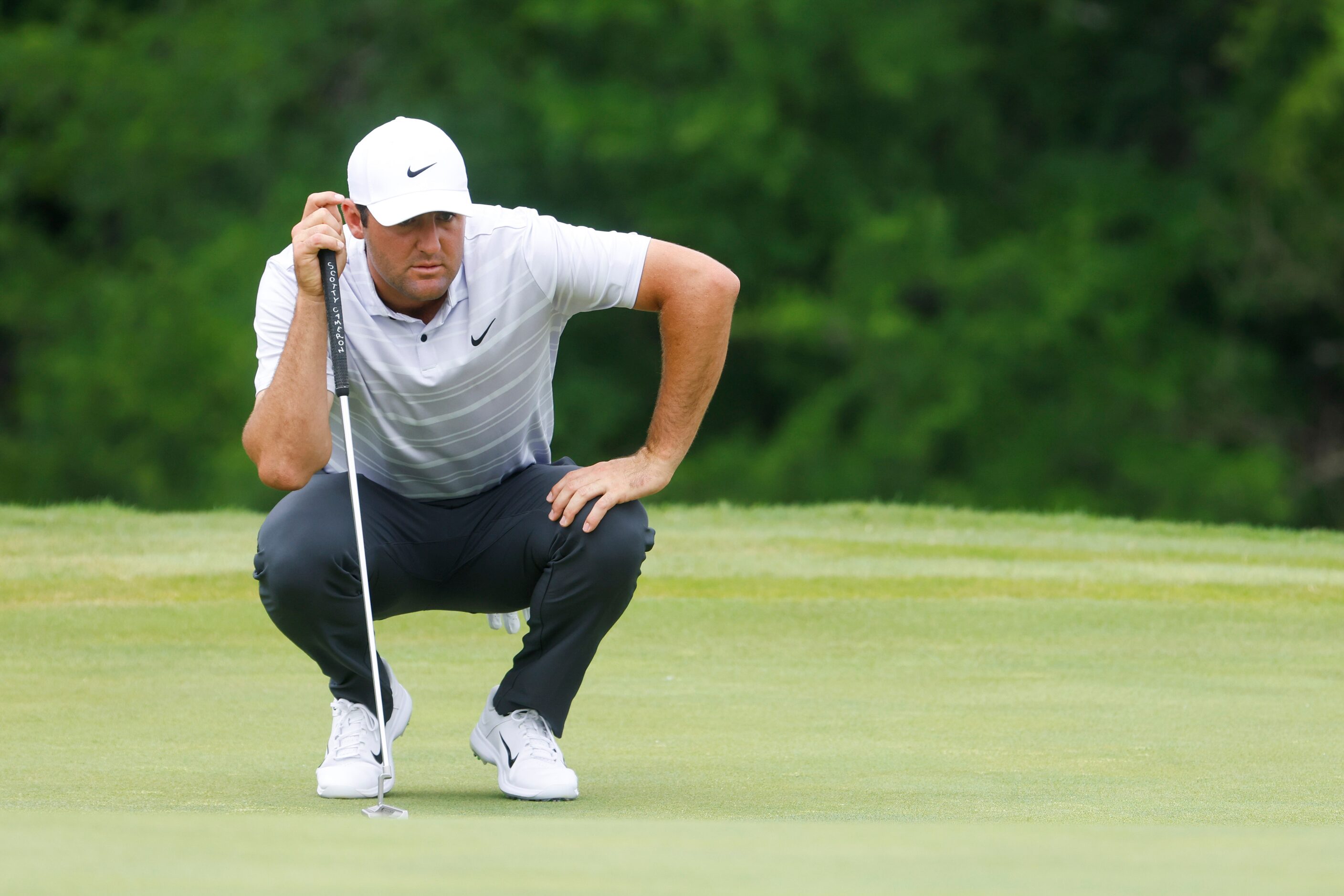 Scottie Scheffler of United States lines up his putt on the ninth hole during the second...