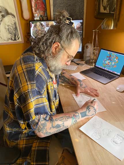 Man sitting at a desk working on drawing illustrations.