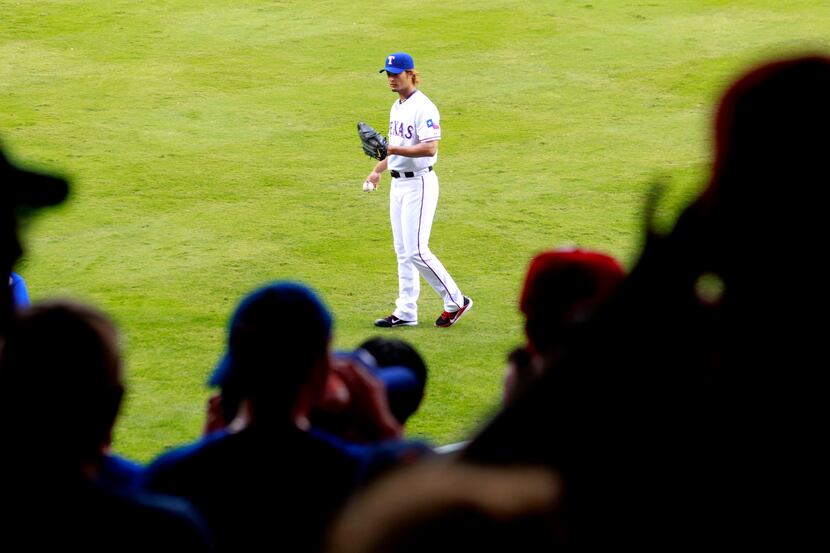 Fans watch as Texas Rangers starting pitcher Yu Darvish (11) warms up prior to playing the...