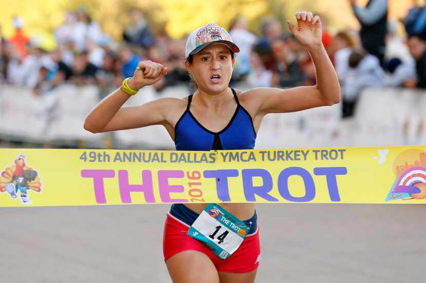 Ingrid Mollenkopf crosses the finish line as the women's winner in the 8-Mile Run during the...