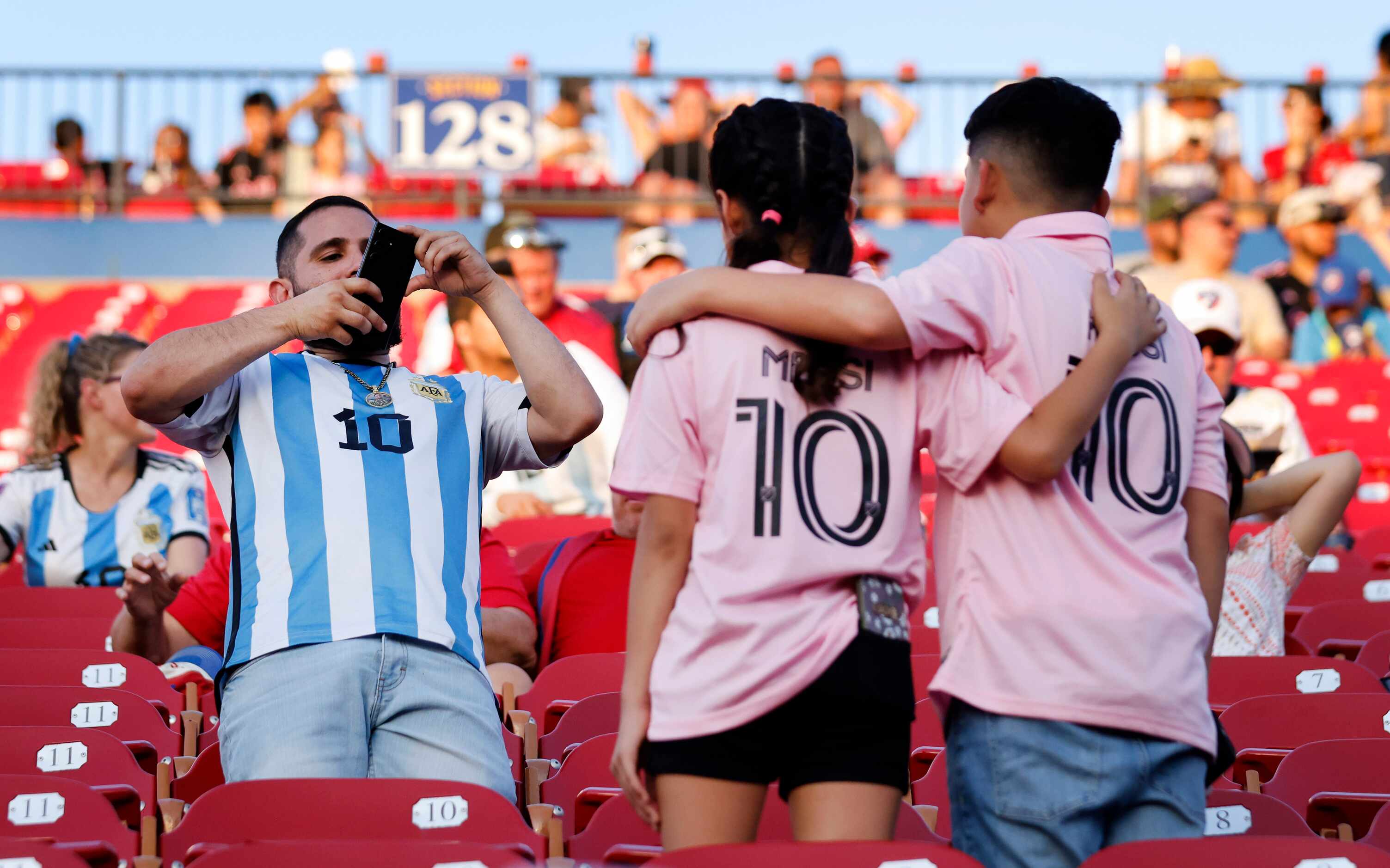 Fans of Inter Miami’s Lionel Messi takes photos of one another before he take the field for...
