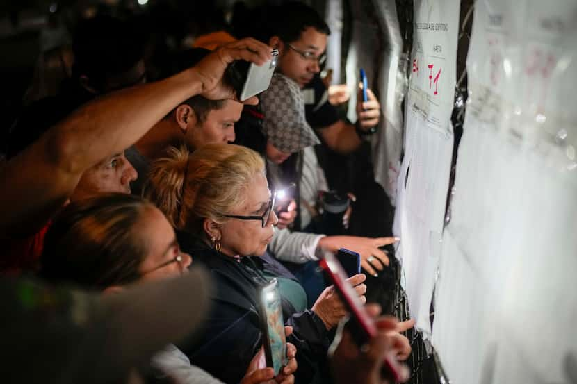 Votantes revisan las listas electorales ante de la apertura de los centros de votación para...