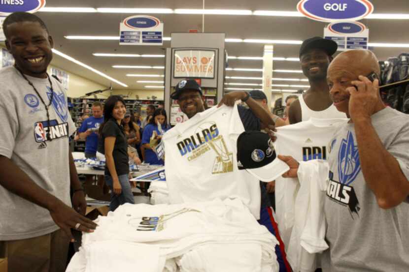Robert Walker of Dallas (center), shows off his new championship t-shirt that he waited over...
