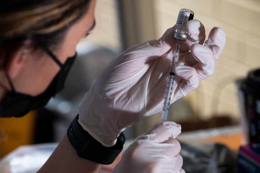 A medical professional prepares a Pfizer vaccine during a pop-up COVID-19 vaccine clinic...