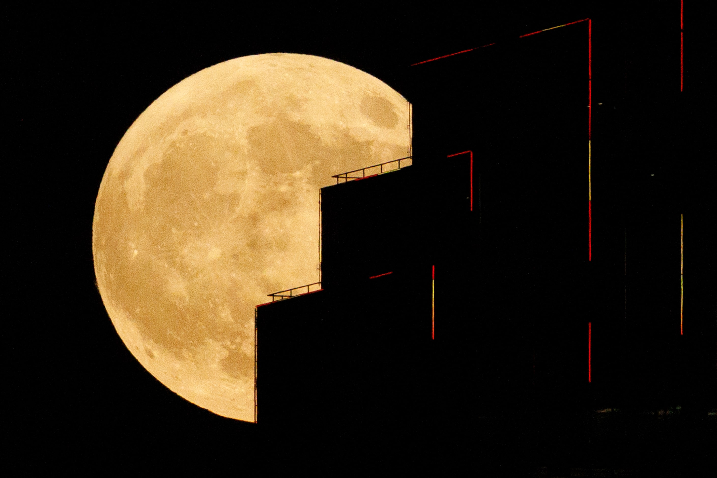 A partial lunar eclipse and supermoon is seen over Bank of America Plaza in downtown Dallas,...