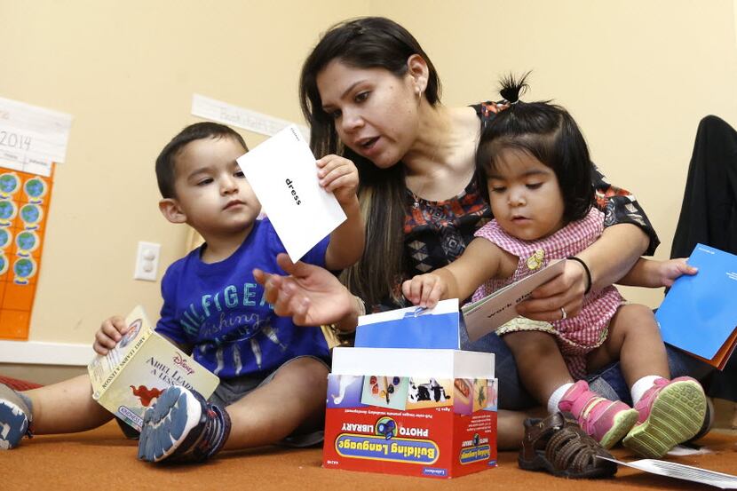 Elizabeth Mancilla, center, one of the teachers at the Child Care Group helps Martin Correa,...