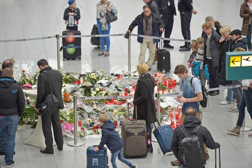 
Travelers stopped Tuesday at a memorial at the airport in Düsseldorf, Germany, for the 150...