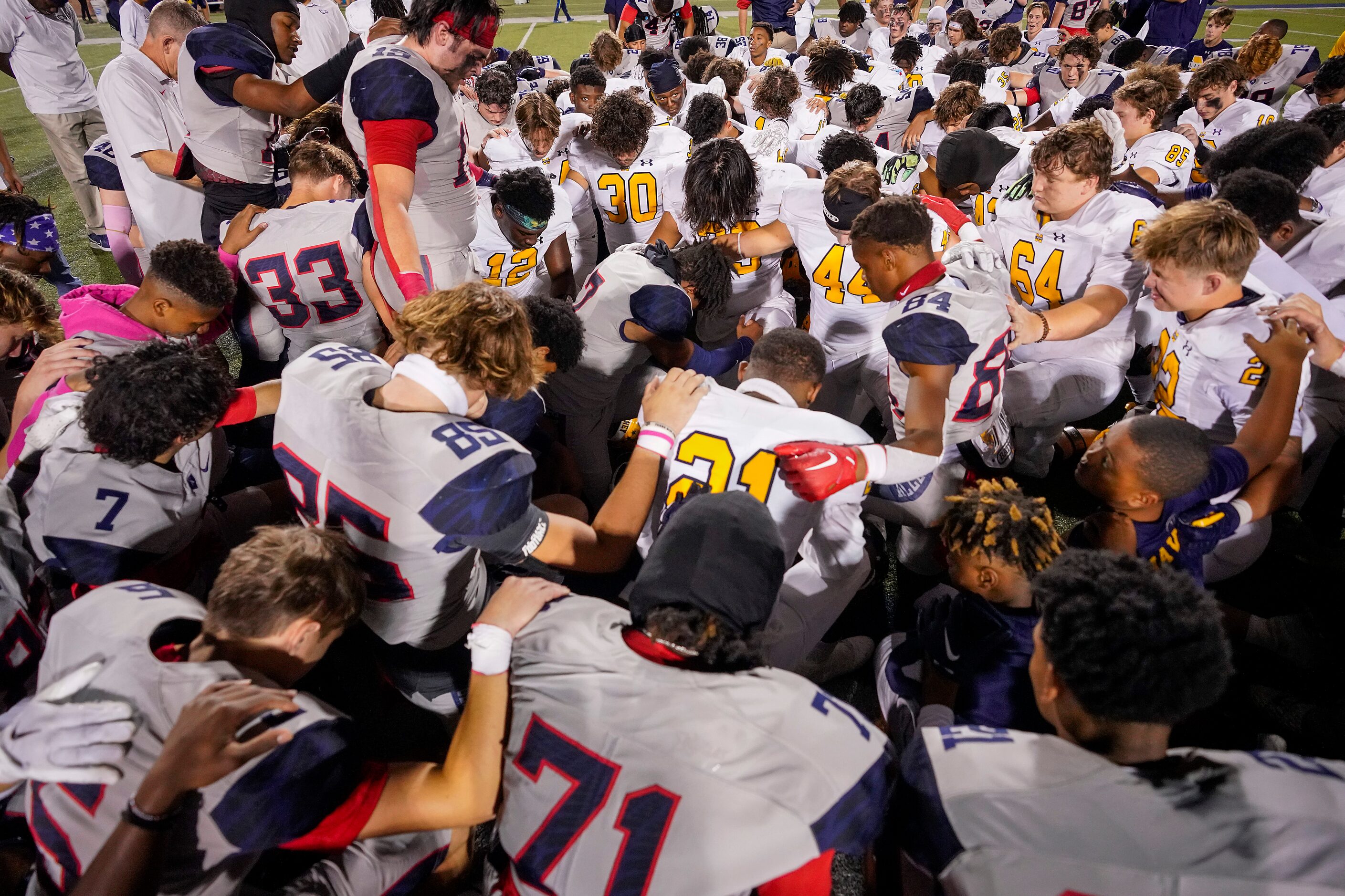 McKinney and Allen players pray at midfield following a District 5-6A high school football...