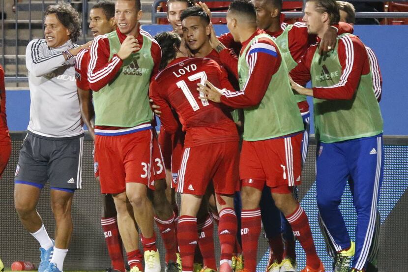 FC Dallas midfielder Victor Ulloa (8) is mobbed by team mates after scoring the go ahead...