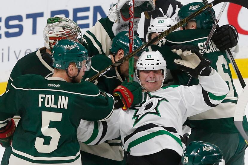 Dallas Stars' Antoine Roussel, right, of France, gets tangled up in a scrum including...