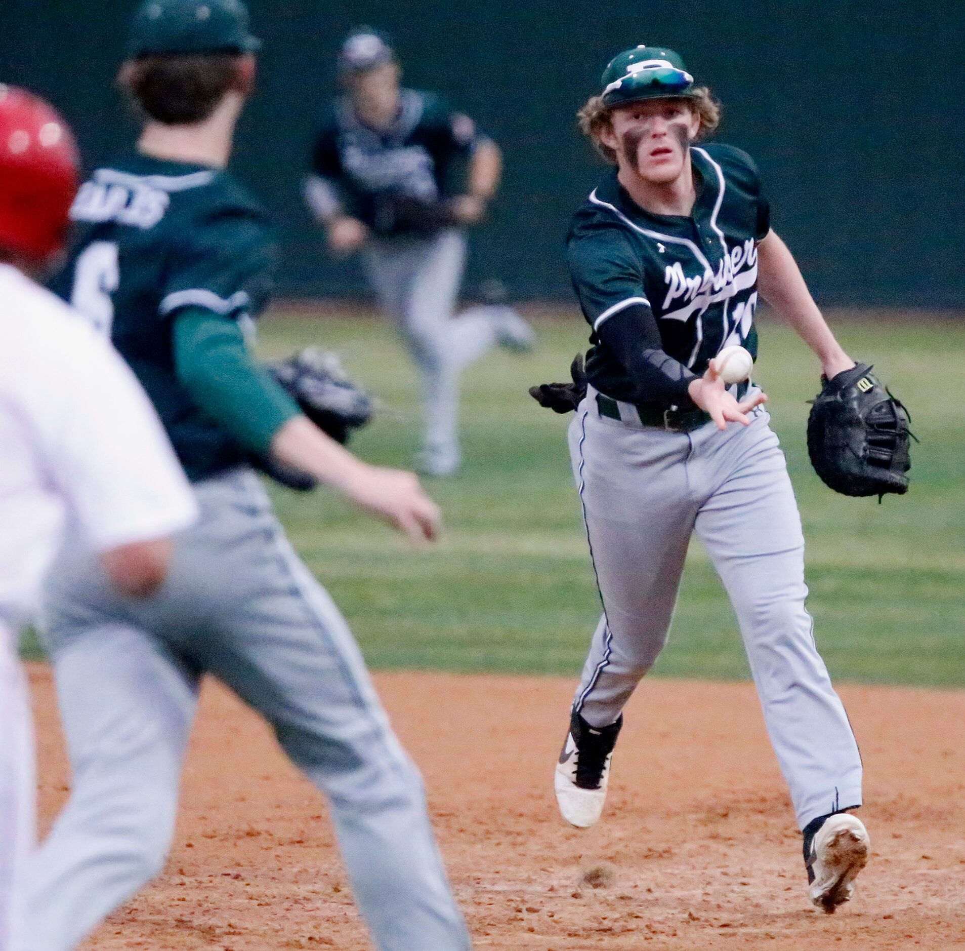 Prosper first baseman Cameron Harpole (10) makes an underhand toss to pitcher Lucas...