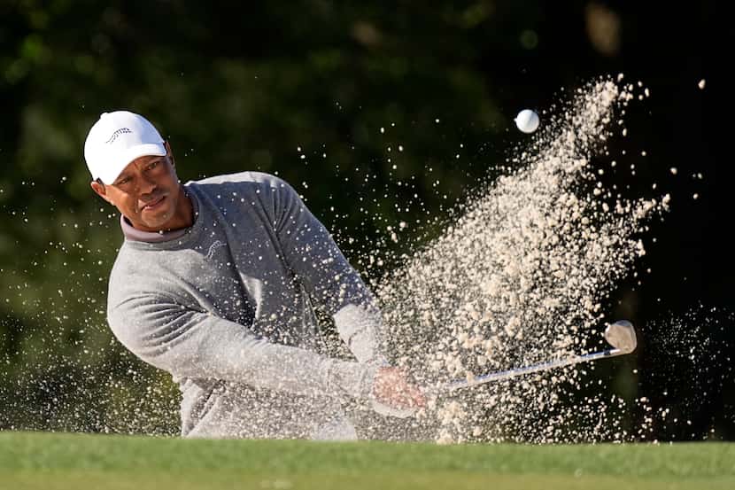 Tiger Woods hits from the bunker on the 18th hole during weather delayed first round at the...