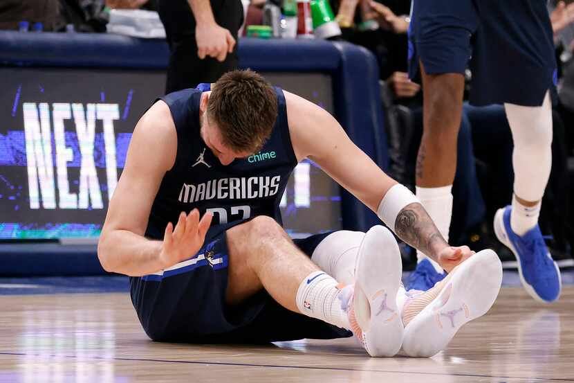 Dallas Mavericks guard Luka Doncic (77) slaps the floor after injuring his leg in the fourth...