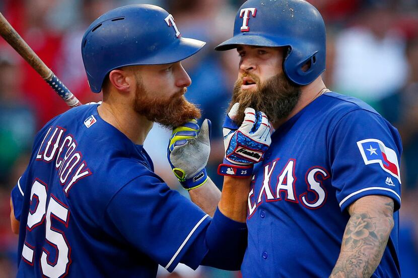 Texas Rangers Mike Napoli (right) and teammate Jonathan Lucroy (25) pull on each others...