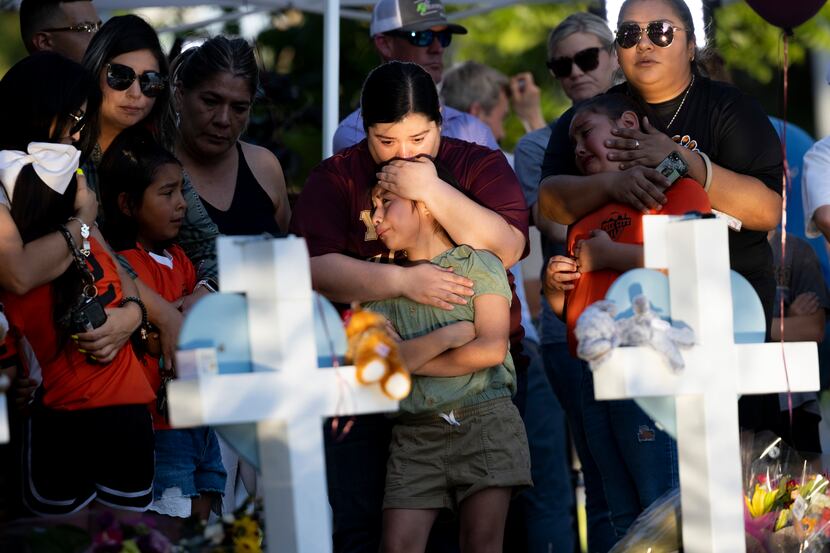 Geneva Uriegas (centro) abraza a su hija Gabriella frente a la cruz en honor a Tess Mata de...