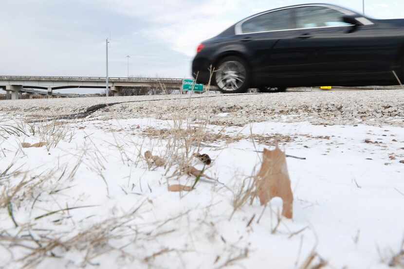 A car passes wind-blown snow along Highway 67 and Interstate 20 on Tuesday morning in...